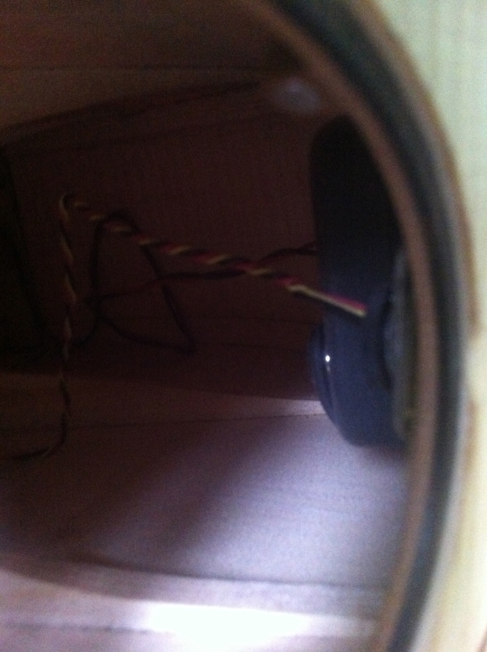 Looking into the soundhole at the volume control and battery pouch beyond